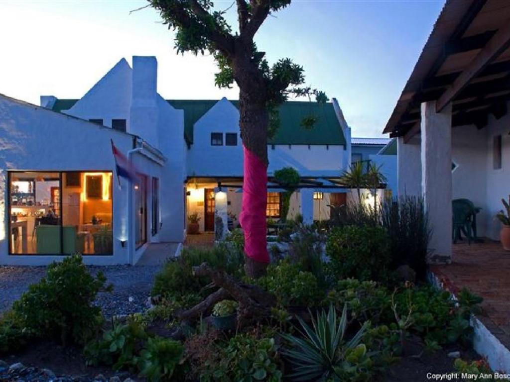 伊泽芳登Kaijaiki Country Inn and Restaurant的一座房子,上面有粉红色的围巾,围着一棵树