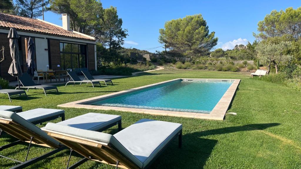 罗尼La Bergerie du Roy-Chambres D'hôtes-的后院设有游泳池、椅子和房屋