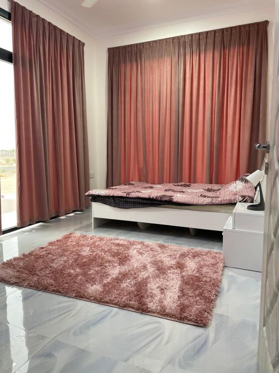 拜尔卡شالية الفضائل的一间卧室配有红色窗帘和地毯的床