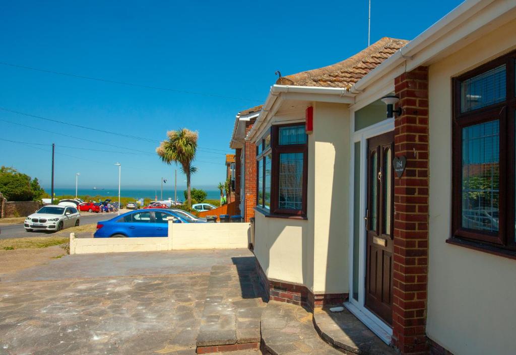 KentBotany Bay Holiday House - Family friendly, 50M from the beach的停车场内有停车位的砖砌建筑