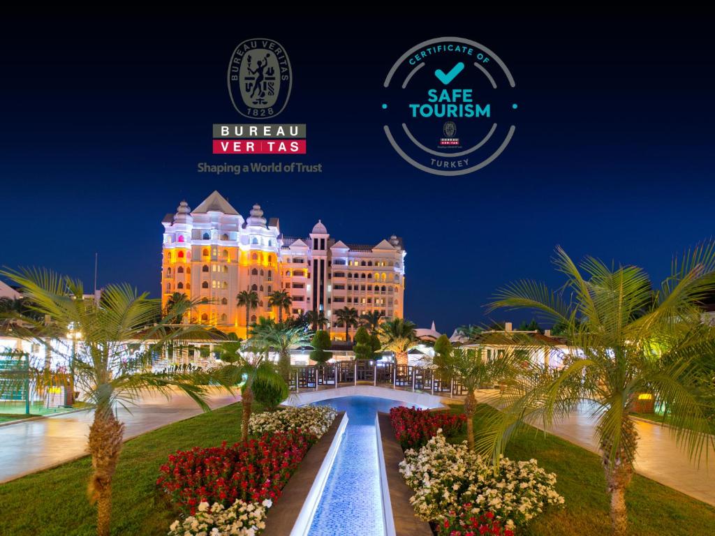 锡德Sentido Kamelya Fulya Hotel & Aqua - Ultra All Inclusive的享有versace酒店和度假胜地的夜间景色