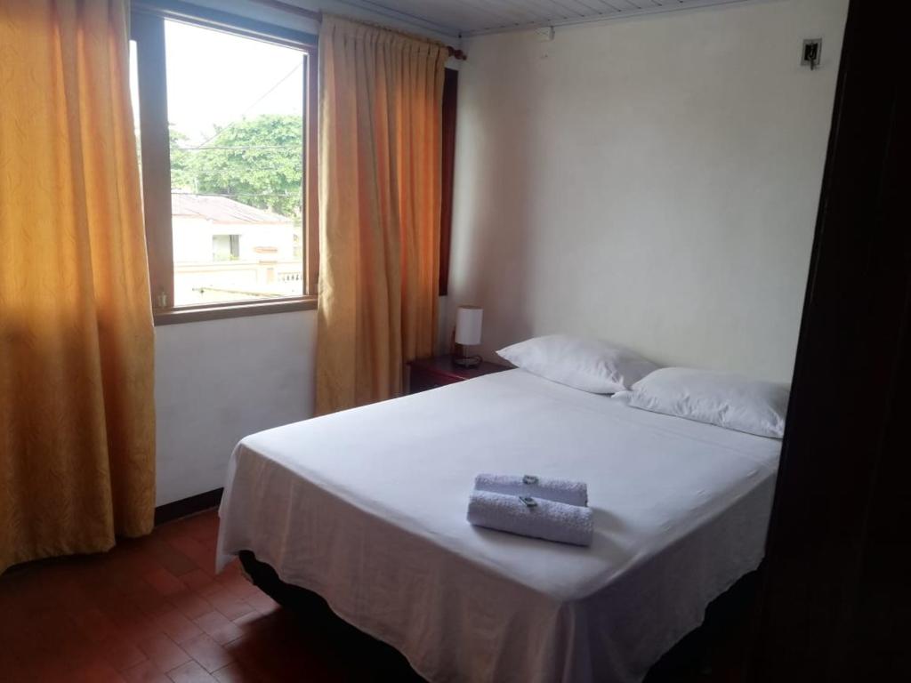 莱蒂西亚Tucuma Casa Hotel的卧室配有白色的床和窗户