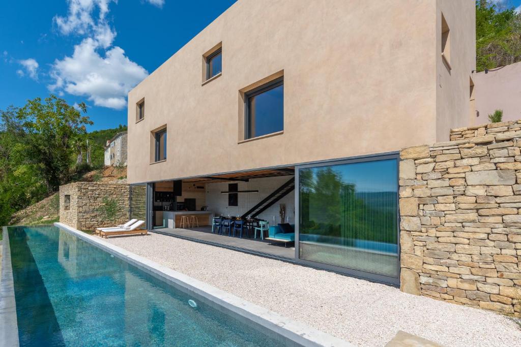 莫托文Villa Terra Motovun的一座房子,设有游泳池,毗邻石墙