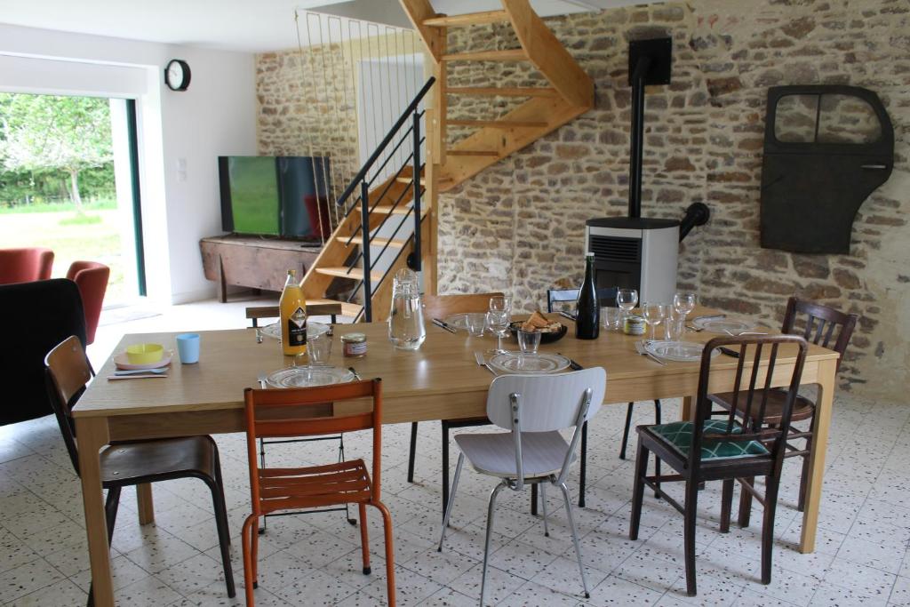 HamarsGîte Le Coq Au Vert en Suisse Normande的一间带木桌和椅子的用餐室