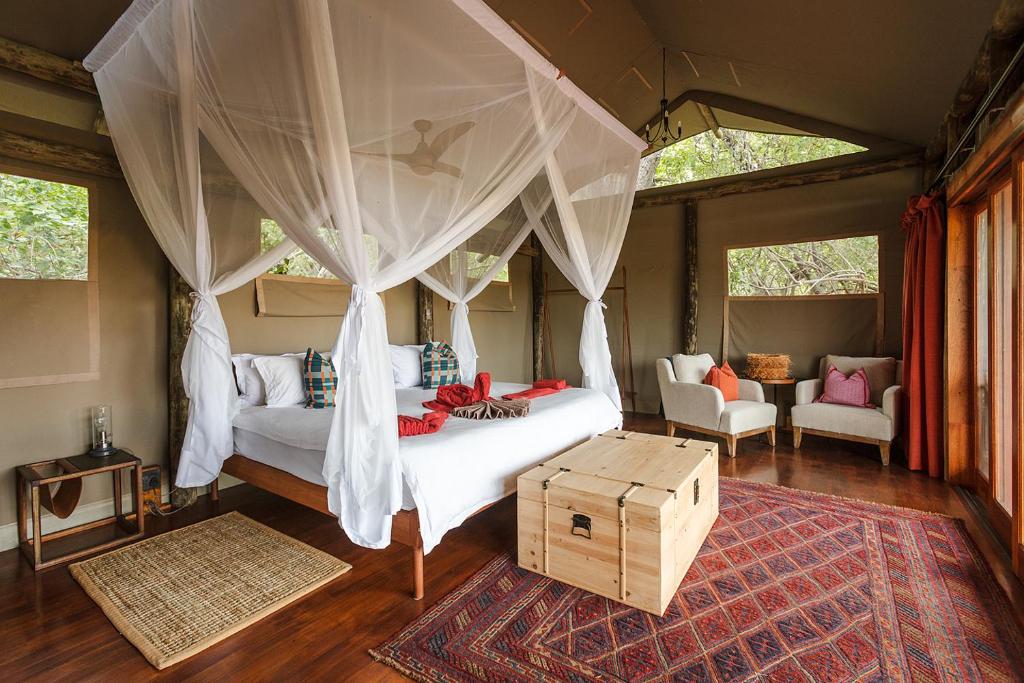 Okavango DeltaAmber River Camp的一间卧室配有一张带天蓬的床
