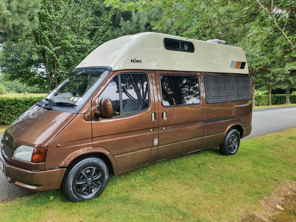 都柏林RETRO CAMPER HIRE LTD Campervan Hire Company "Travel Throughout Ireland "的一辆面包车,在路边装有露营车