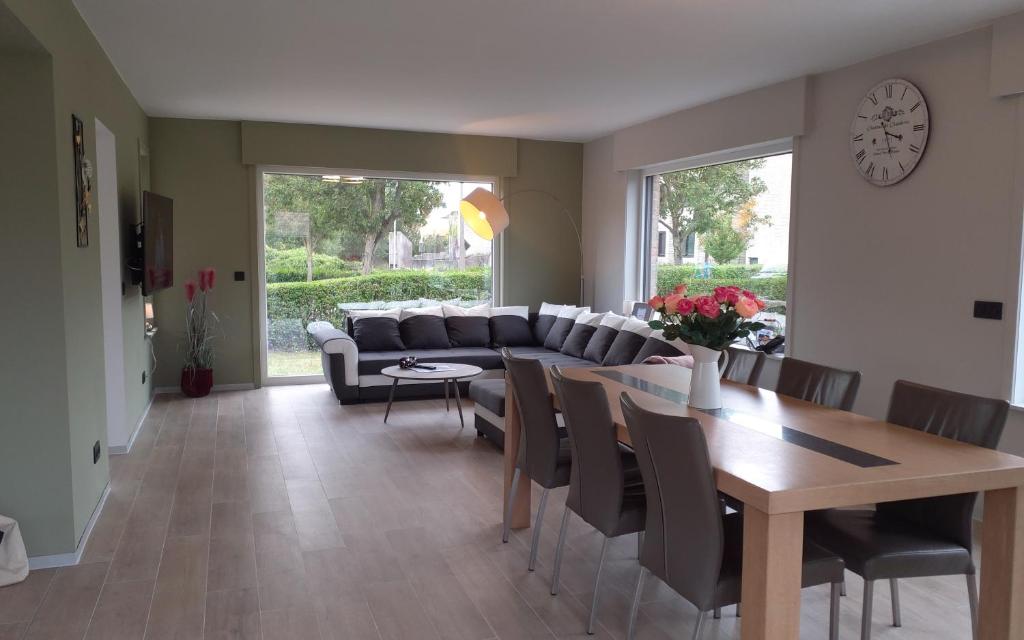尼乌波特Villa 't Zonneroosje的客厅配有沙发和桌椅