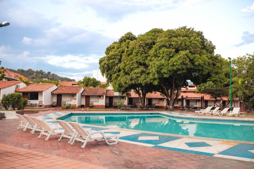 库库塔Hotel Faranda Bolivar Cucuta, a member of Radisson Individuals的一个带躺椅的游泳池以及一棵树