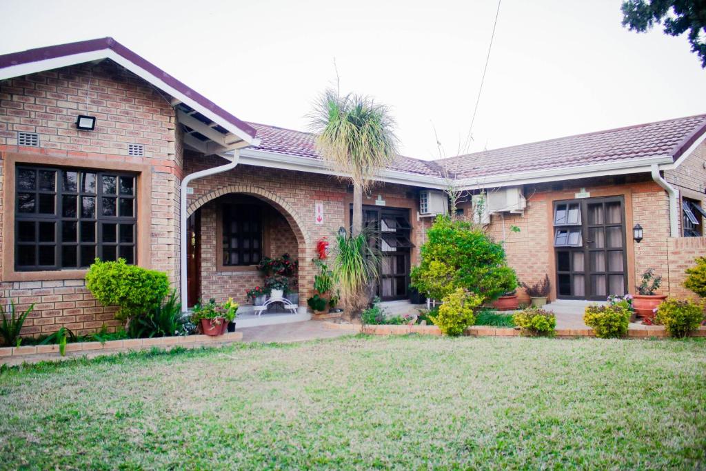 LobatsePitikwe Hill Guesthouse的院子里有棕榈树的砖房