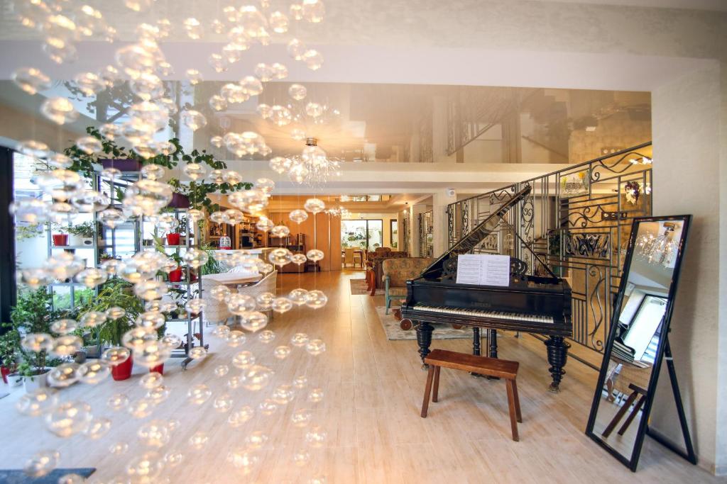 第比利斯Hotel Kera的客厅配有钢琴和圣诞树