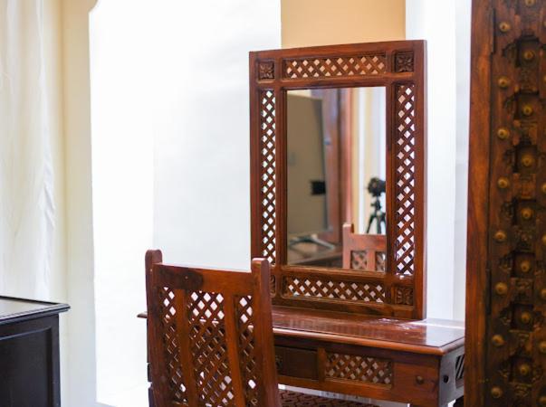 迪拜Heritage Home Guest House的木桌上放着一面木镜子