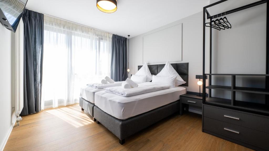 蒂宾根Hotel Metropol的一间卧室设有两张床和大窗户