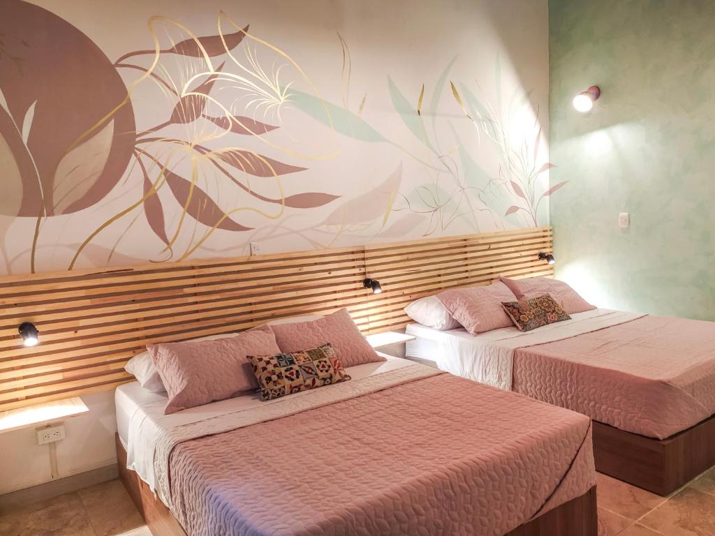 麦德林Neim Platinum Hotel的墙上壁画的房间里设有两张床