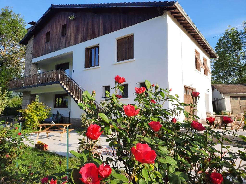 MoulisLe Jardin de Moulis - Maison d'hôtes au pied des Pyrénées, Ariège, Saint Girons的前面有红玫瑰的房子