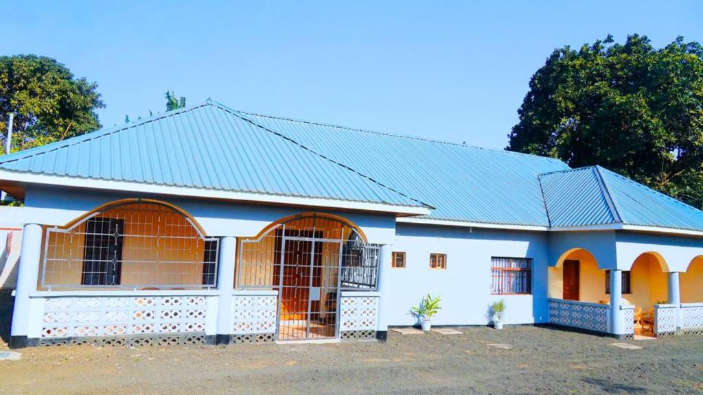阿鲁沙Osotwa Maasai Hostel的蓝色的白色房子,屋顶蓝色