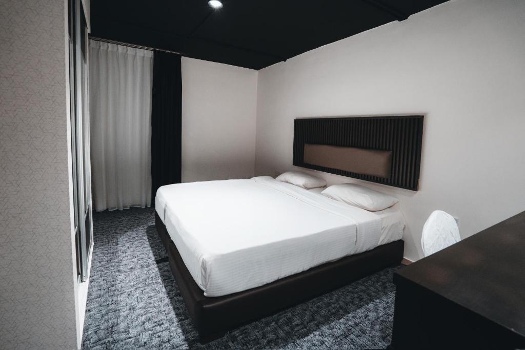 安曼Diamond Hotel的一间卧室配有一张白色的床和黑色床头板