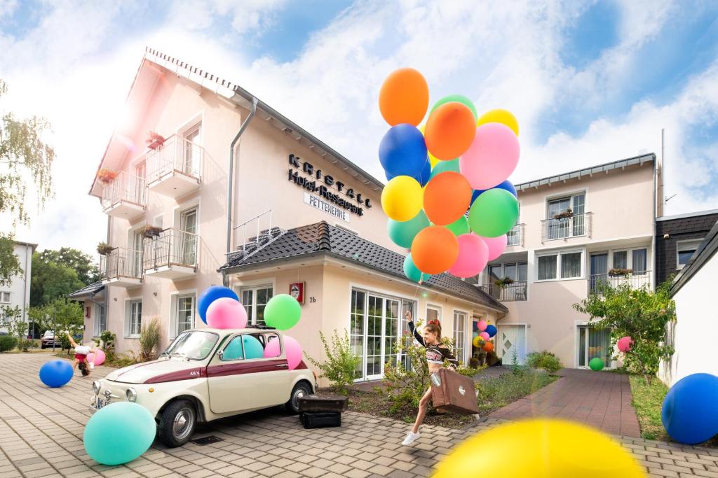勒沃库森Kristallhotel Fettehenne的女人站在一辆装有气球的汽车旁边