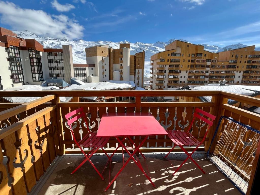 葱仁谷Val Thorens Studio 4 pers Résidence La Roche Blanche的雪覆盖的山景阳台上摆放着红色的桌椅