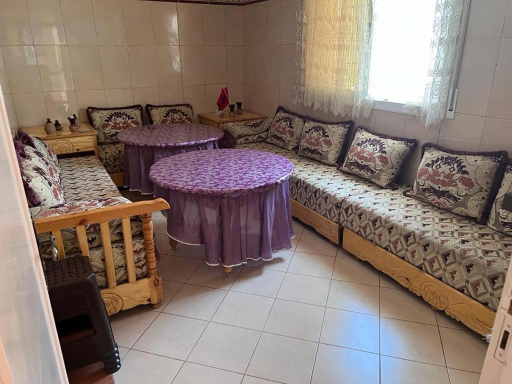 纳祖尔2 Zimmer Wohnung Corniche Nador Sidi Ali- am Meer & Wifi的客厅配有两张桌子和一张沙发