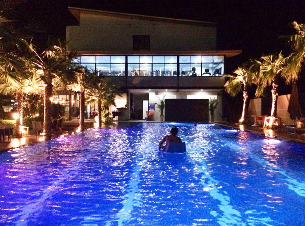 武里南雷武里南酒店 的夜间在度假村游泳池里的人