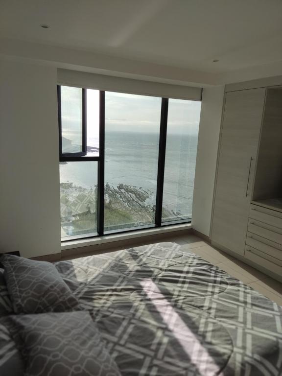曼塔Departamento Suite frente al mar Poseidon Manta的一间卧室设有一张床,享有海景