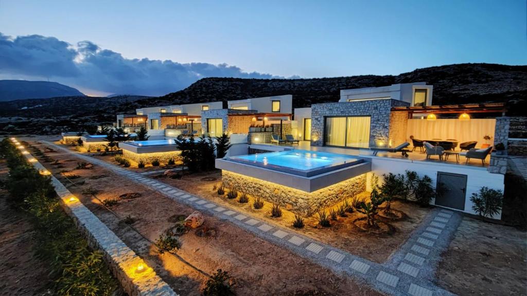卡尔帕索斯Aros Luxury Villas的夜间带游泳池的别墅