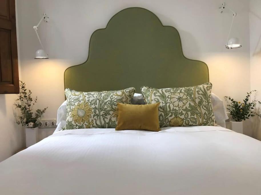 莱昂Lloēco - Art & Design Guest House的一张带绿色床头板和枕头的大型白色床