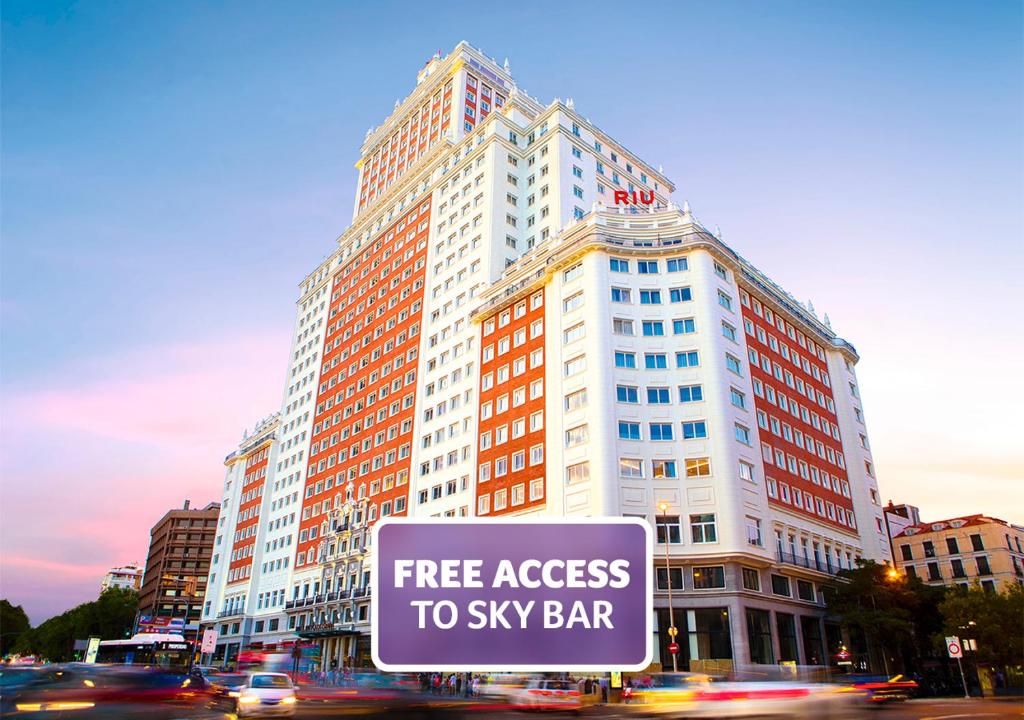 马德里Riu Plaza España的一座大型建筑,可免费进入天空酒吧标志