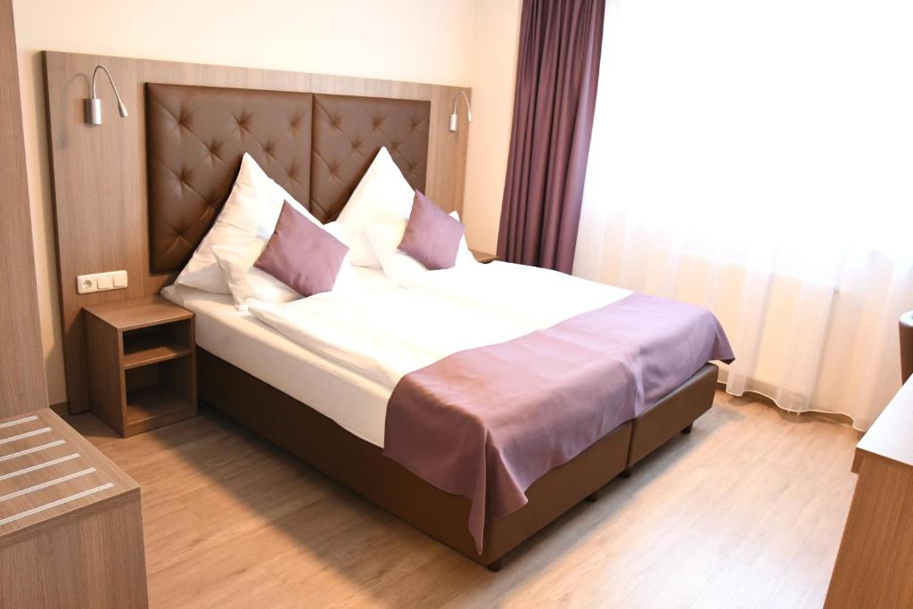 汉堡Ata Hotel - Self Check-in的一间卧室配有一张带枕头的大床