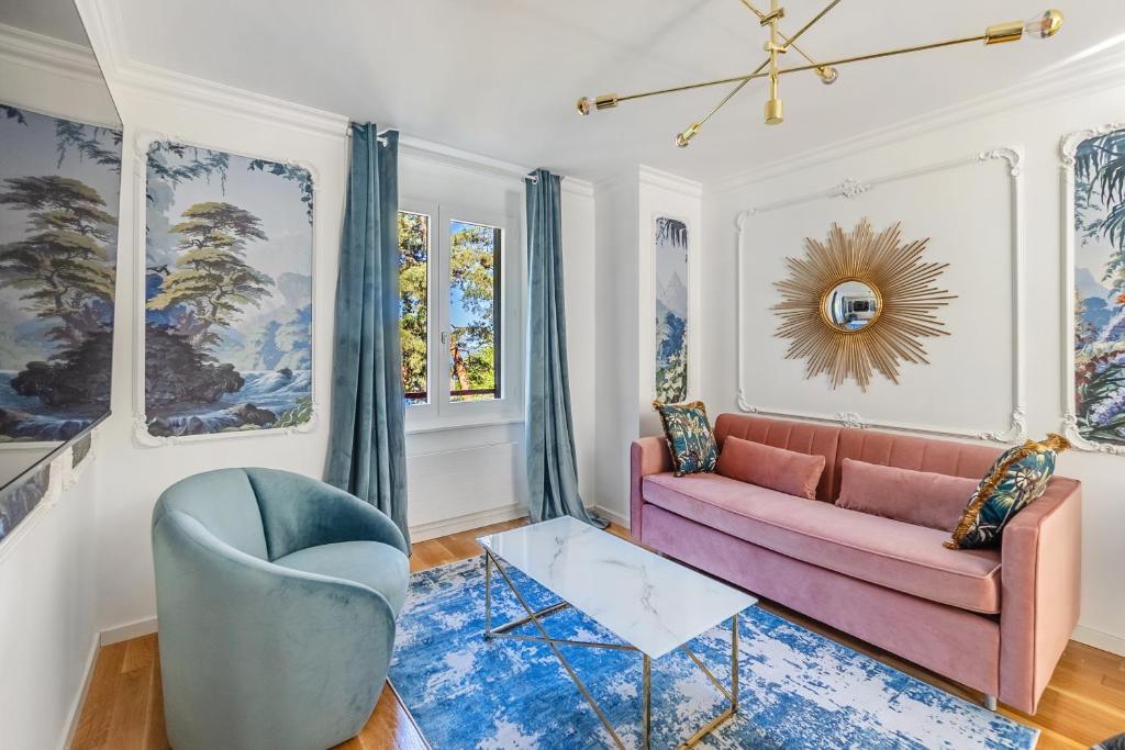 蒙特勒Bon Port 1-bedroom apartment – Lakefront的客厅配有粉红色的沙发和蓝色的椅子