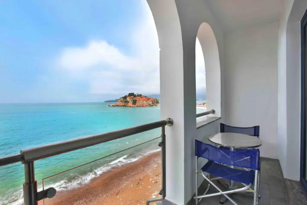 斯韦蒂·斯特凡Plava Vila Beach Apartments Sveti Stefan的阳台配有桌子,享有海景。