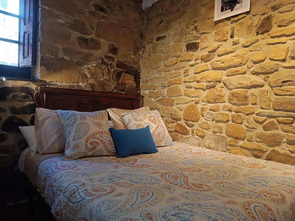 米耶雷斯La Castañar - La Vallicuerra Casas Rurales的石墙房间内的一张床位
