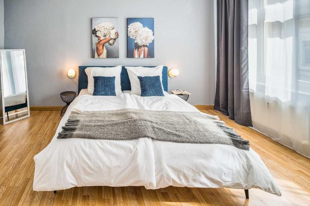 梅森cozy Apartment SOLARIS in Meißen Altstadt Netflix的卧室配有带蓝色枕头的大型白色床