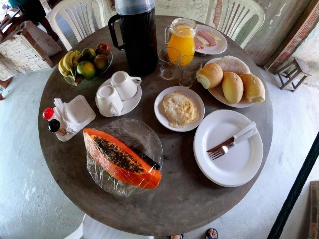 CruzMila chalé的一张桌子,上面放着早餐食品和橙汁