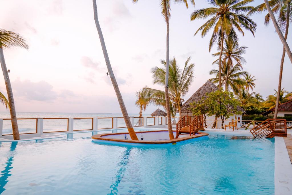 布韦朱TIKI Beach Club & Resort的一座棕榈树和海洋游泳池