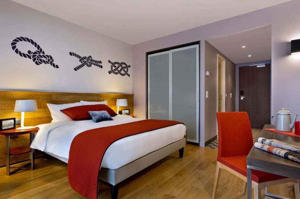 汉堡汉堡米歇尔馨乐庭服务公寓公寓式酒店的一间卧室配有一张大床、一张桌子和一张桌子