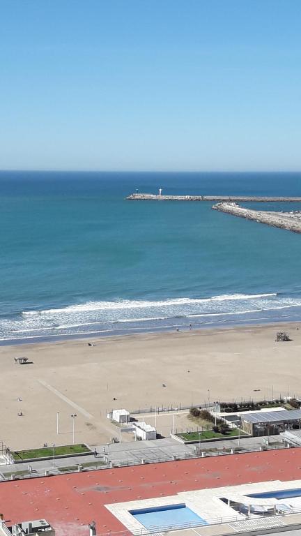 马德普拉塔Playa Grande Studio Golf y Playa的享有海滩、大海和码头的景色