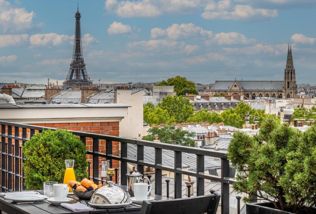 巴黎Hôtel Pont Royal Paris的阳台的桌子享有艾菲尔铁塔的景色