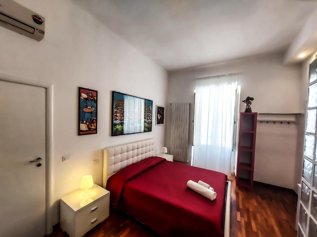 塔兰托Casa Flora的一间设有红色床和窗户的小卧室