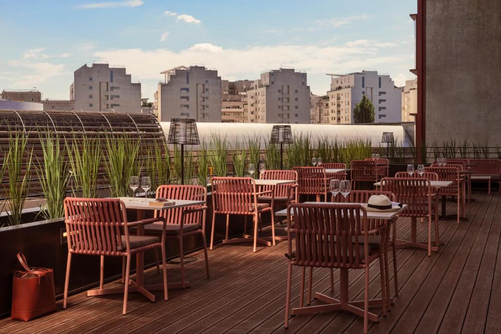 楠泰尔OKKO Hotels Paris La Défense的一间在甲板上配有桌椅的餐厅