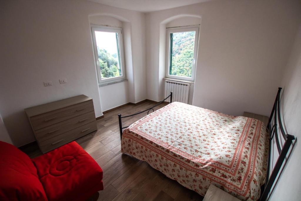 日科德尔格尔福迪艾斯Near - Cinque Terre Holiday Apartment的一间卧室设有一张床和两个窗户。
