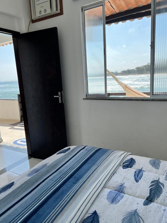 里约热内卢Casa Marambaia 2的一间卧室设有一张床,享有海景