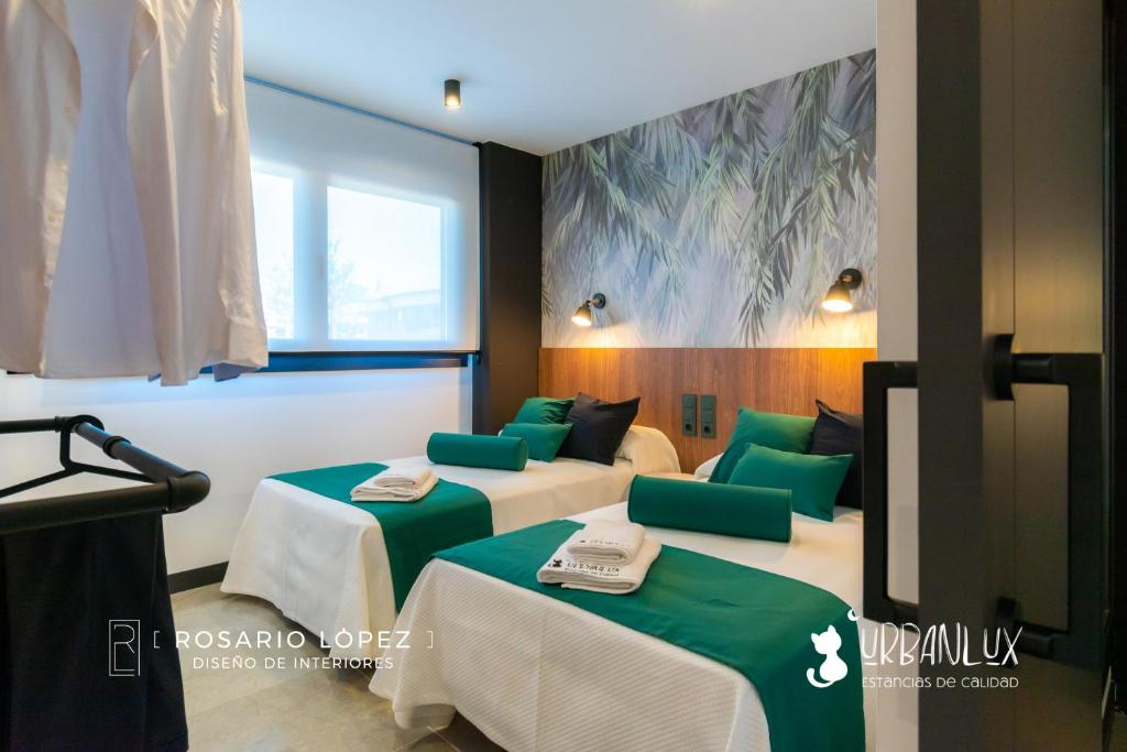 阿尔巴塞特Urbanlux Olimpia Pet Friendly的客房设有两张带绿色靠垫的床。