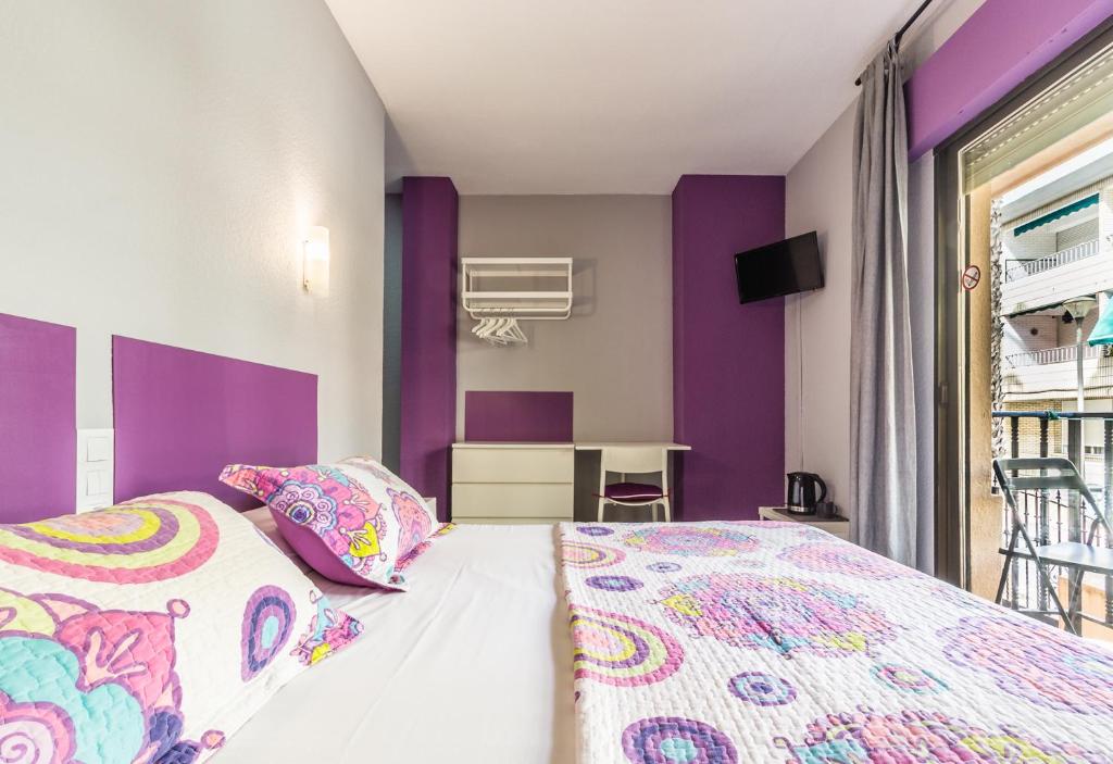 阿尔姆尼卡Hostal Tropical的卧室拥有紫色和白色的墙壁,配有1张床