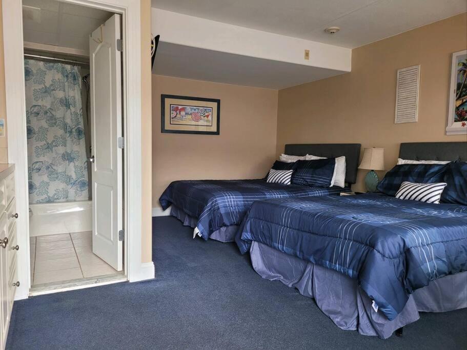 大洋城Sunbeach Condo 900 Wesley Avenue Unit 109的一间卧室设有两张床,一扇门设有窗户