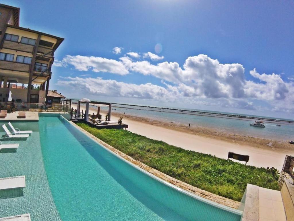 拉巴拉德纳圣米格尔Apartamento em Barra Bali, Resort de Luxo - Destino BSM 329的海滩旁带游泳池的度假村