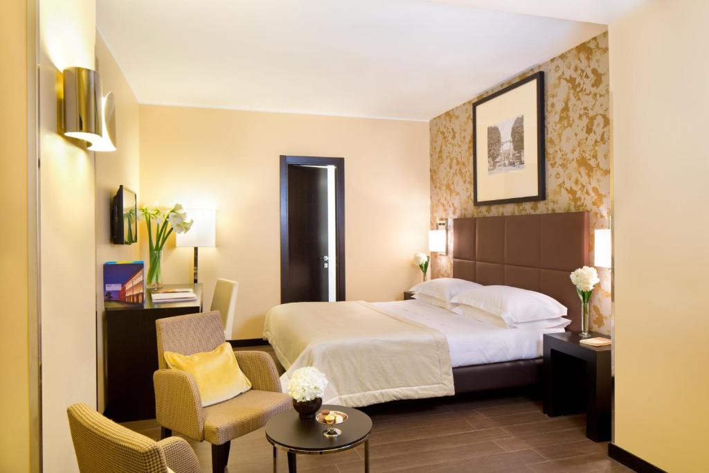 都灵玛杰斯缇克星际酒店的酒店客房带一张床、一张桌子和椅子