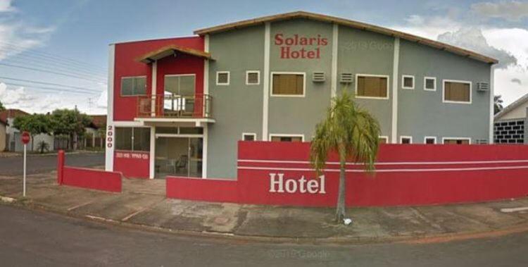 特雷斯拉瓜斯Hotel Solaris的一座酒店大楼,前面有棕榈树