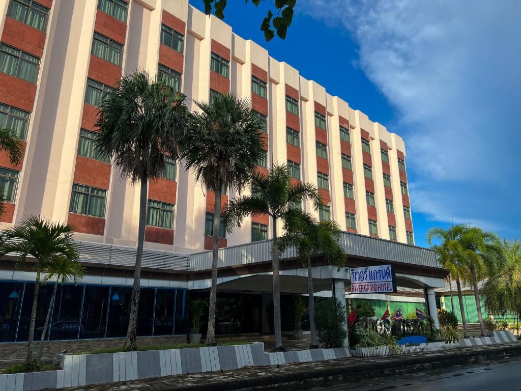 合艾大河酒店的一座棕榈树环绕的大建筑