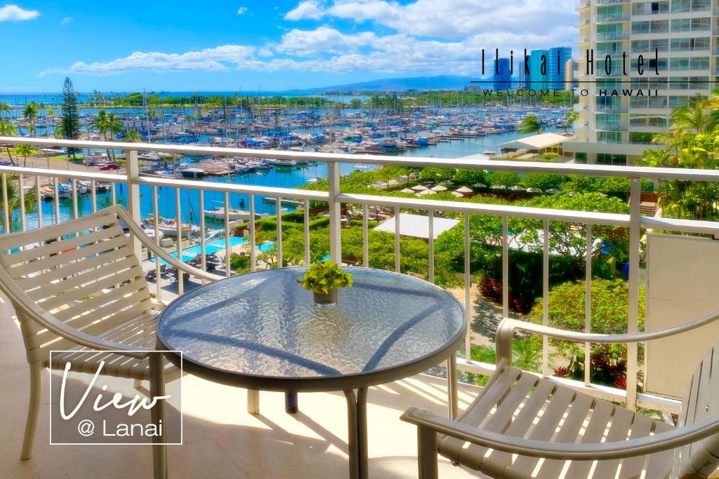 檀香山New Aloha Ilikai 1free Parking的阳台配有桌椅和海港